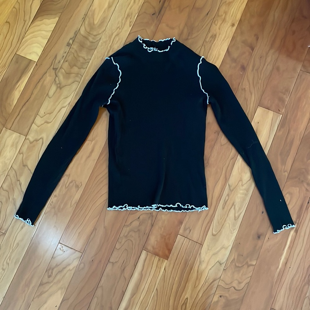 black turtleneck with white ruffled trim